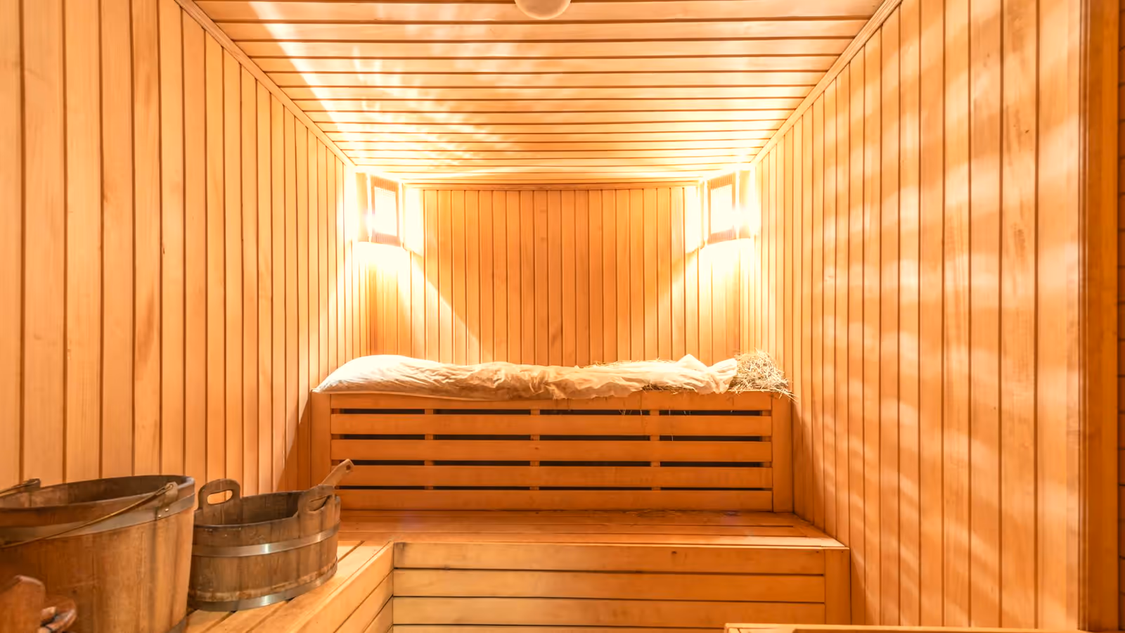 Warm wooden sauna interior lit by soft lamplight